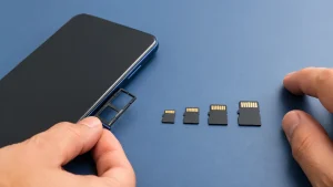 Celular Android com bandeja de cartão aberta e quatro cartões microSD organizados para comparação.
